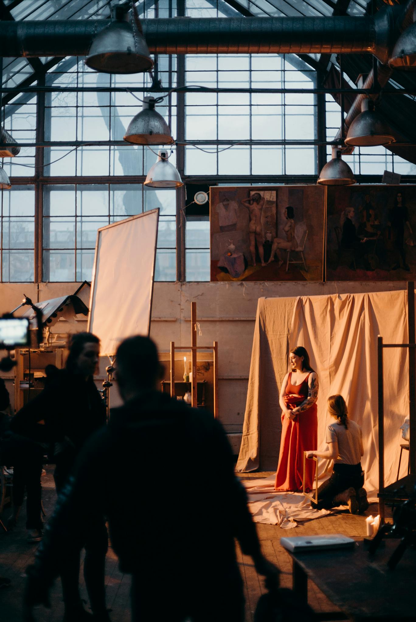 A behind-the-scenes look at a professional photo studio with a model posing for a photoshoot.
