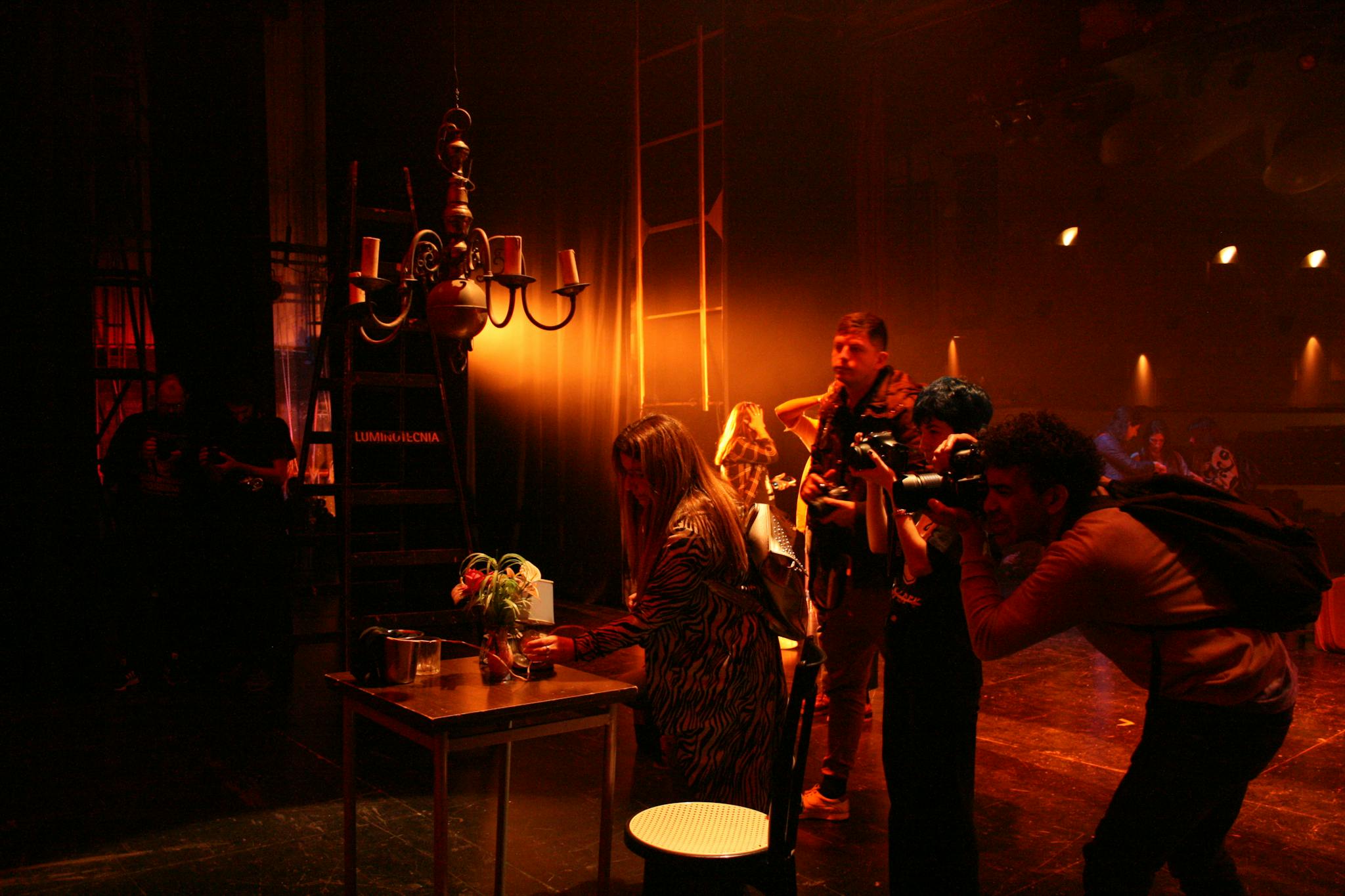 A team of photographers in action on a dramatic theater stage setting.